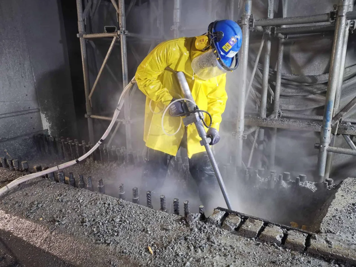 High-pressure water blasting stripping a concrete surface